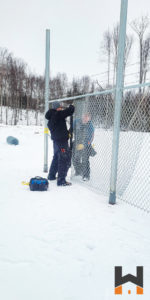 Working Hands LLC crew working on a commercial chain link fence in Wasilla, Alaska
