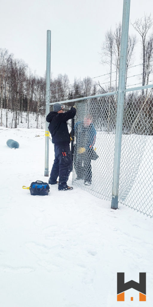 Working Hands LLC crew working on a commercial chain link fence in Wasilla, Alaska