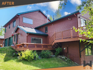 Side view of fully painted residential home with green garage doors and wood siding